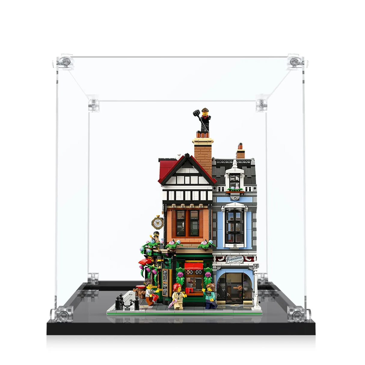 Lego-Modell eines Hauses mit Schornsteinfeger auf dem Dach in einer Vitrine