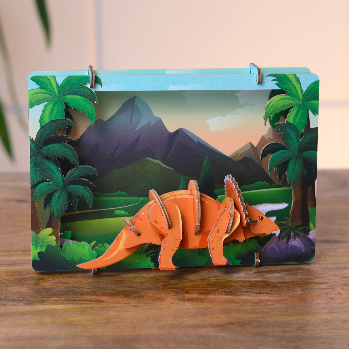 3D Pappmodell eines Triceratops vor einer Dschungelkulisse mit Bergen