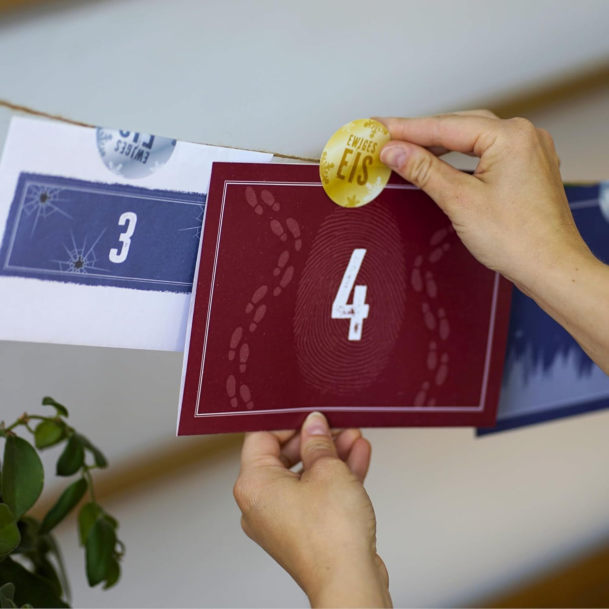 Hände befestigen eine rote Karte mit der Nummer 4 und Fußspuren an einer Schnur