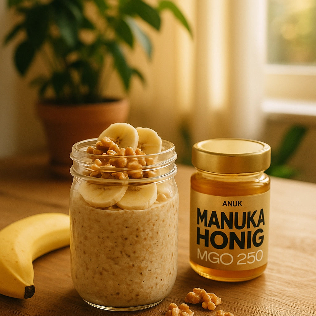 Haferbrei mit Bananen und Walnüssen in einem Glas neben einem Glas Manuka Honig und einer Banane