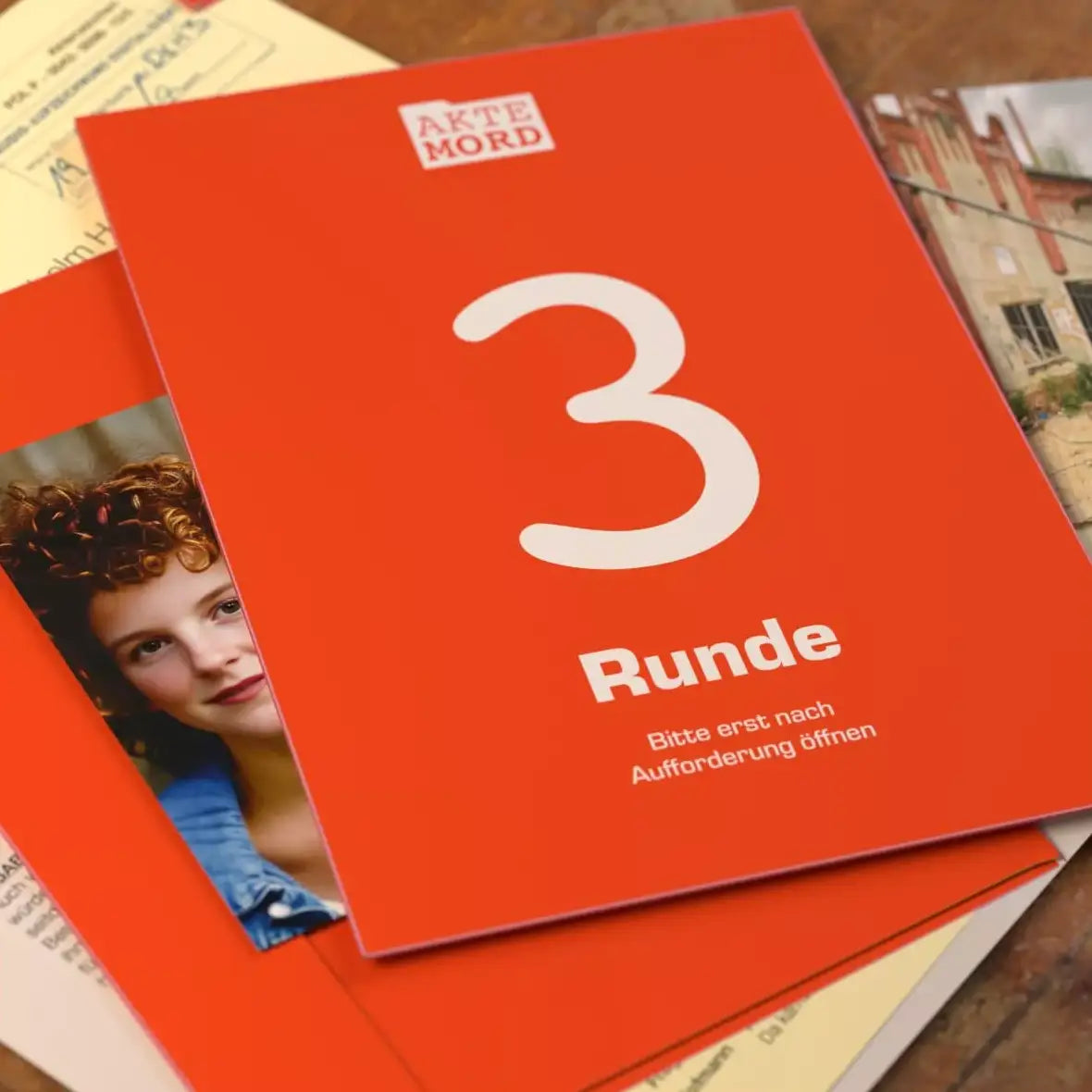 Rote Spielkarte mit der Aufschrift Akte Mord Runde 3 und dem Hinweis Bitte erst nach Aufforderung öffnen