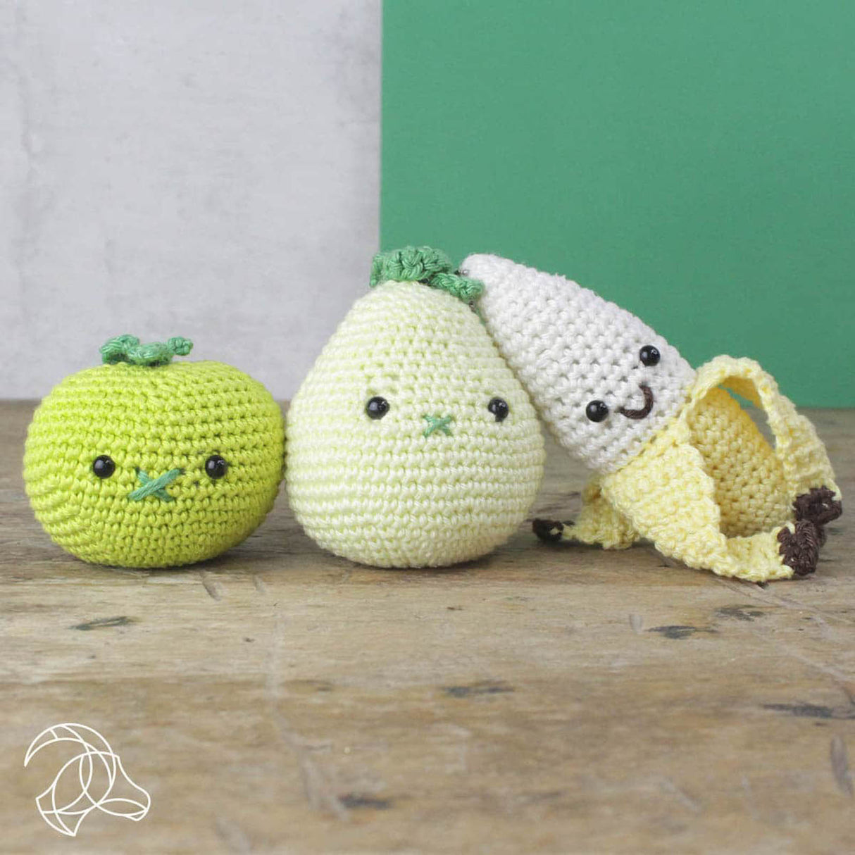 Drei gehäkelte Figuren in Form von Apfel Birne und Banane mit aufgestickten Gesichtern
