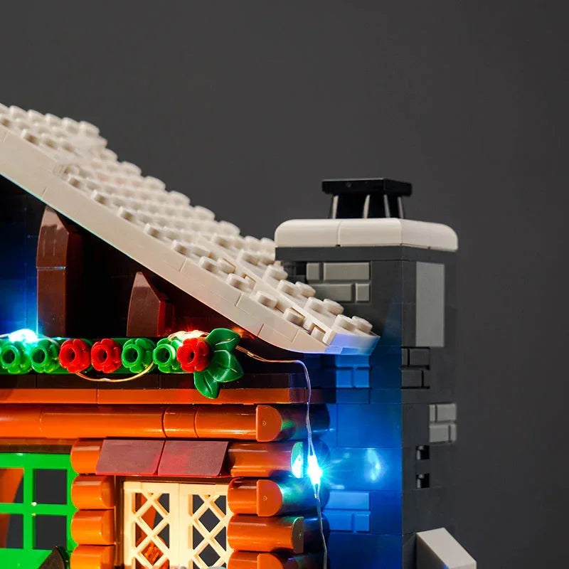 Detailansicht eines beleuchteten Lego Blockhauses mit Schornstein und weihnachtlicher Dekoration