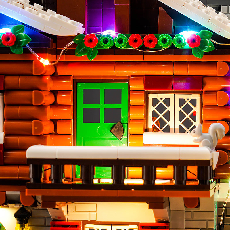 Beleuchtetes Lego Blockhaus mit grüner Tür und weihnachtlicher Dekoration
