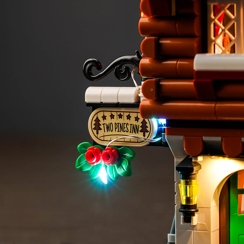 Beleuchtetes Two Pines Inn Schild an einem Lego Gebaeude mit Stechpalmenzweig