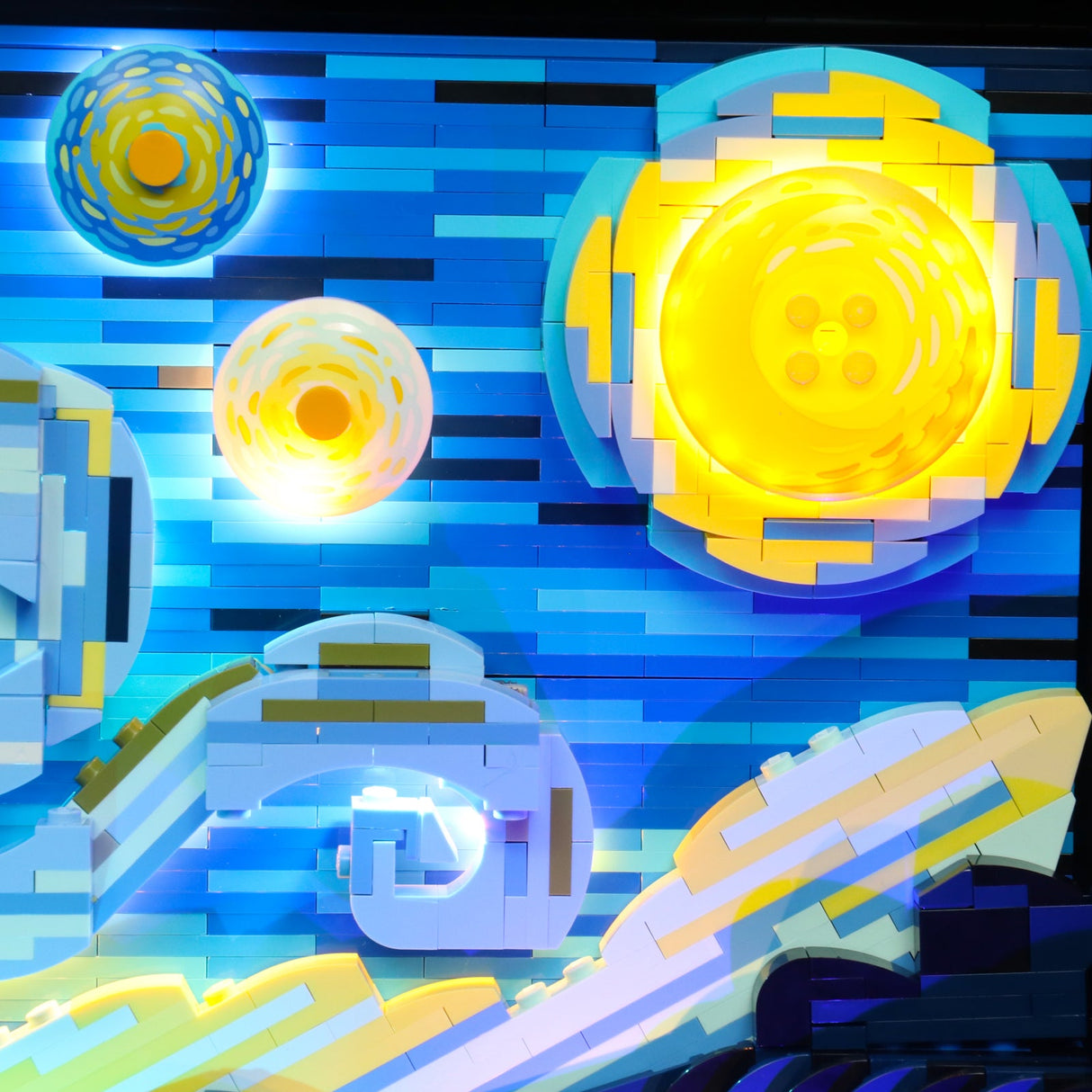 Wandbild aus Lego Steinen mit abstraktem Sternenhimmel und leuchtenden gelben Kreisen auf blauem Hintergrund