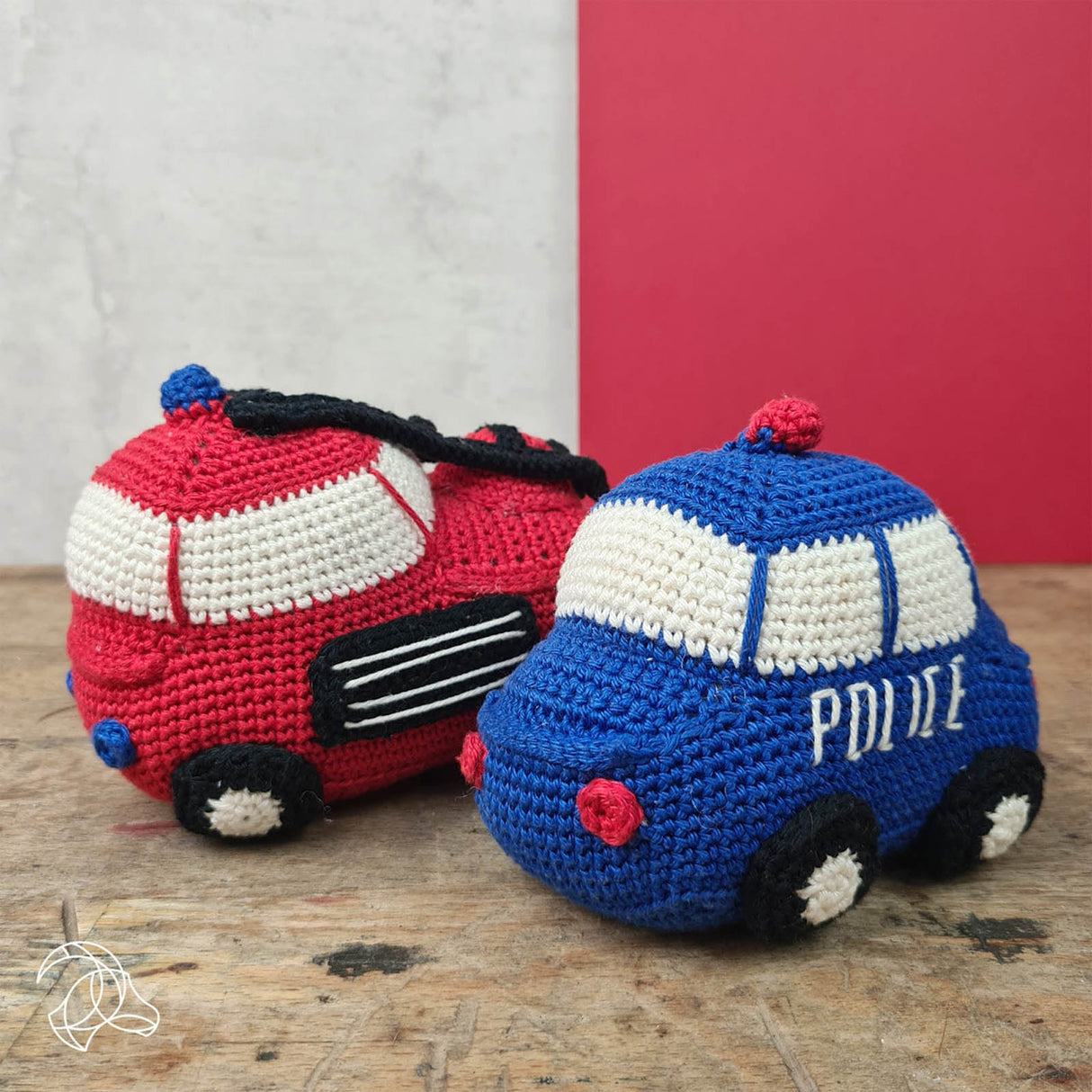 Gehäkelte Spielzeugautos als Feuerwehr und Polizeiwagen