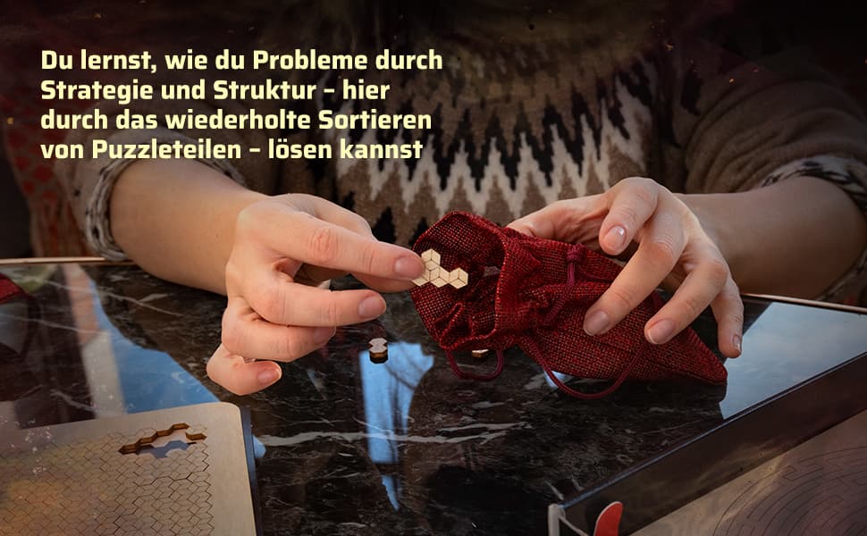 Nahaufnahme von Händen, die ein hexagonales Holzteilsortieren und in einen roten Stoffbeutel legen, mit Text zu Strategie und Struktur.