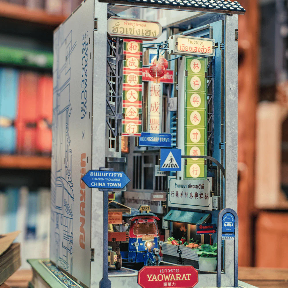 Miniatur-Diorama einer belebten Straße in Chinatown mit Tuk-Tuk und vielen Schildern