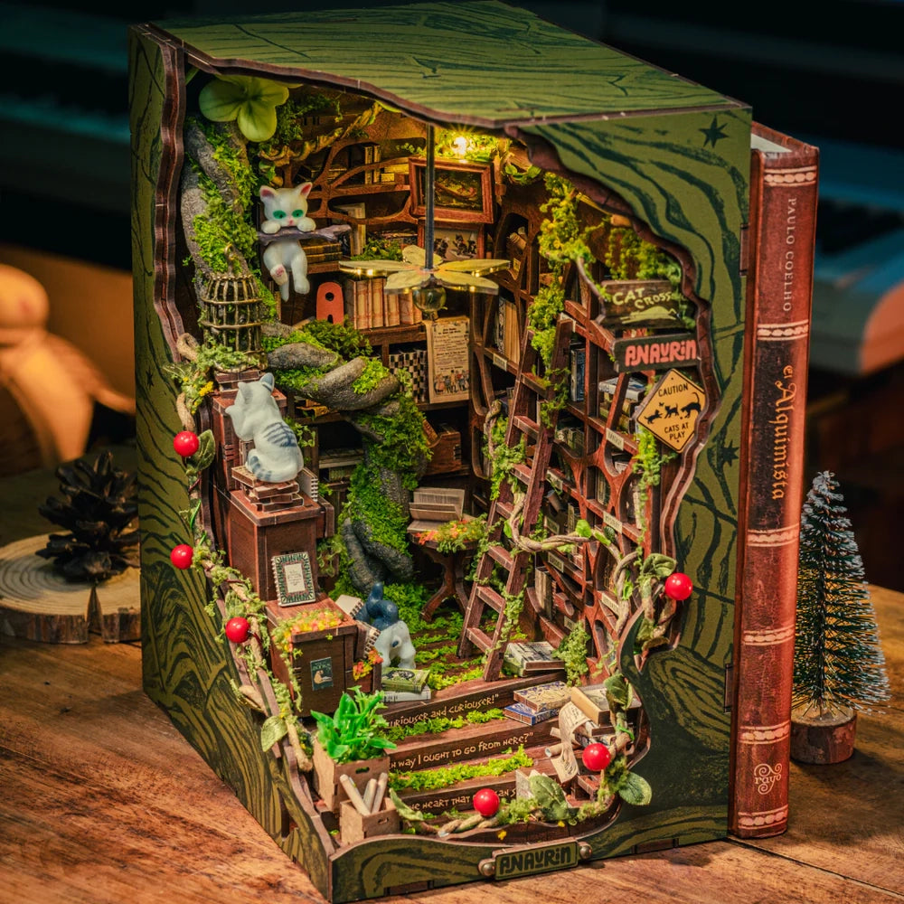 Ein Bücherregal-Einsatz mit einem Miniatur-Katzen-Bücherregal, das mit Moos und kleinen roten Beeren verziert ist