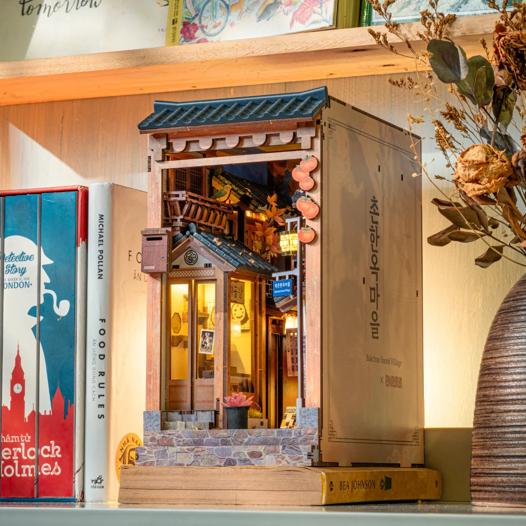 Miniaturmodell eines koreanischen Hanok Hauses als Buchstütze zwischen Büchern im Regal