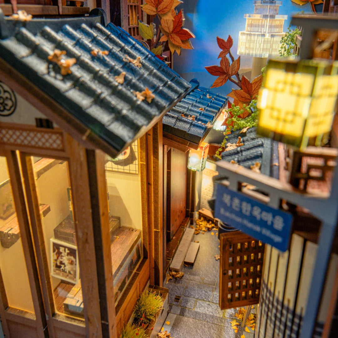 Miniaturmodell eines traditionellen koreanischen Dorfes mit beleuchteten Laternen und herbstlicher Dekoration