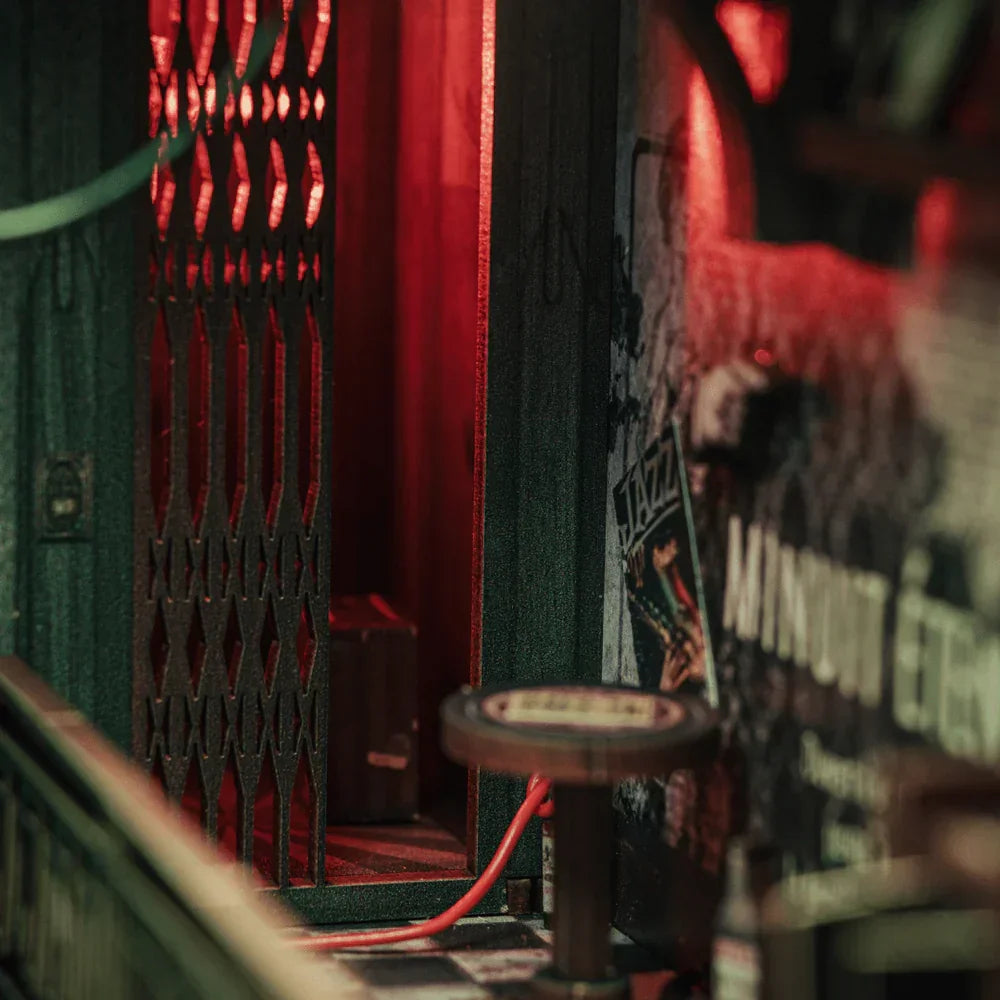 Miniatur-Jazzclub mit roter Beleuchtung, Gittertür und Barhocker