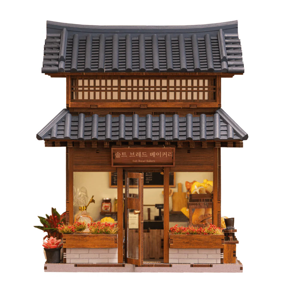 Miniatur-Bäckerei mit traditionellem koreanischem Dach und Schaufenster mit Brot und Blumenkästen