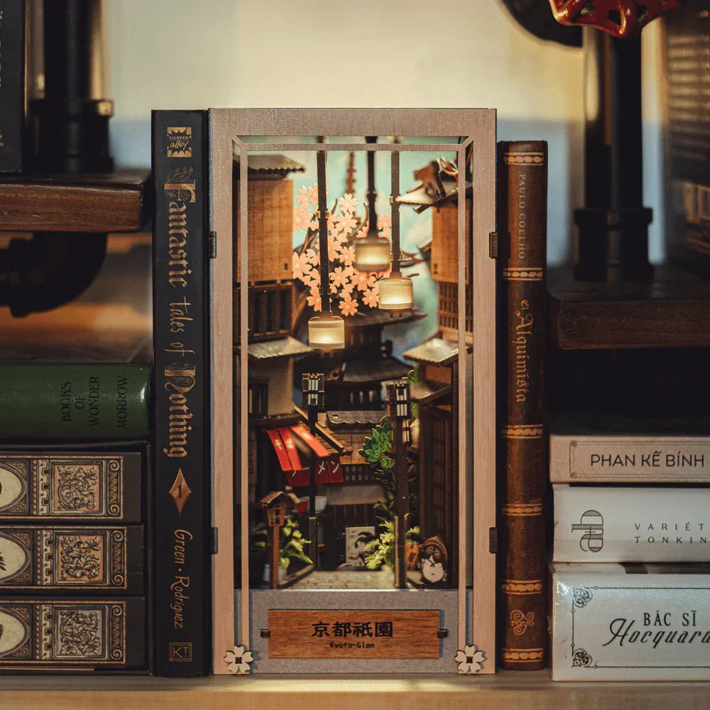 Miniatur-Diorama eines japanischen Viertels mit Kirschblüten und Laternen, umgeben von Büchern