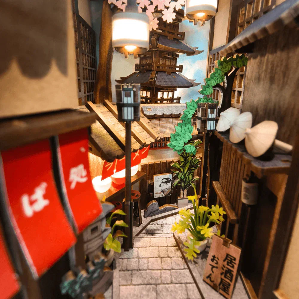 Miniatur-Diorama einer japanischen Gasse mit traditionellen Gebäuden, roten Bannern und einem Tempel im Hintergrund