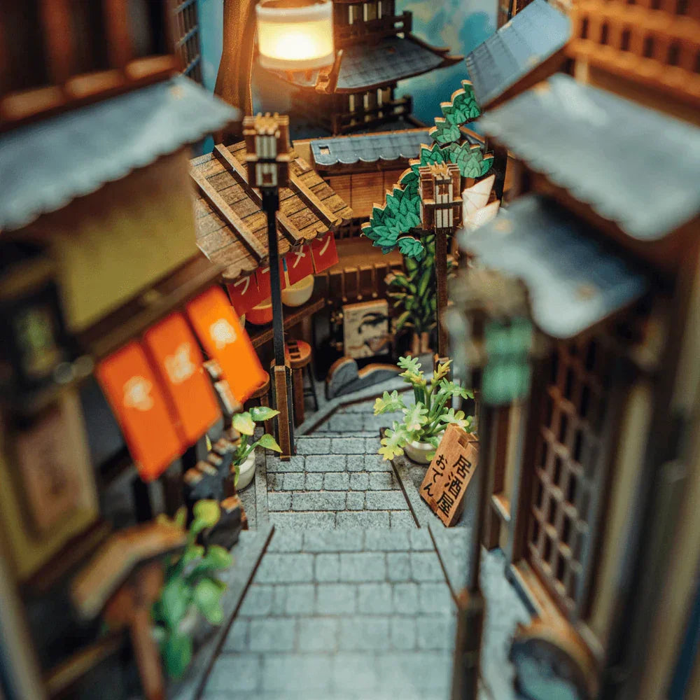 Miniatur-Diorama einer japanischen Gasse mit Kopfsteinpflaster, Gebäuden, Laternen und Pflanzen