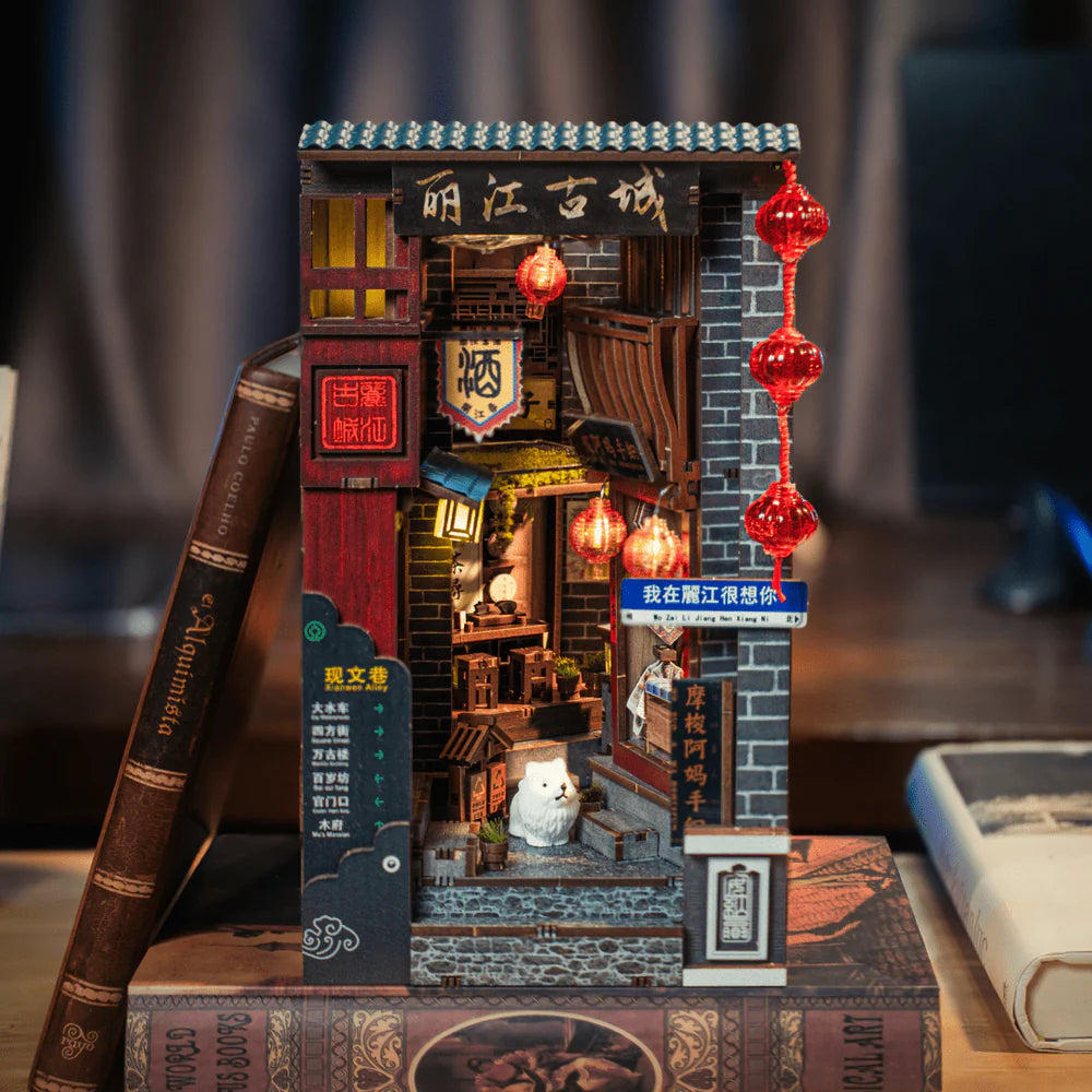 Miniatur-Bücherregal-Einsatz mit beleuchteter Gasse, roten Laternen und einem kleinen weißen Hund