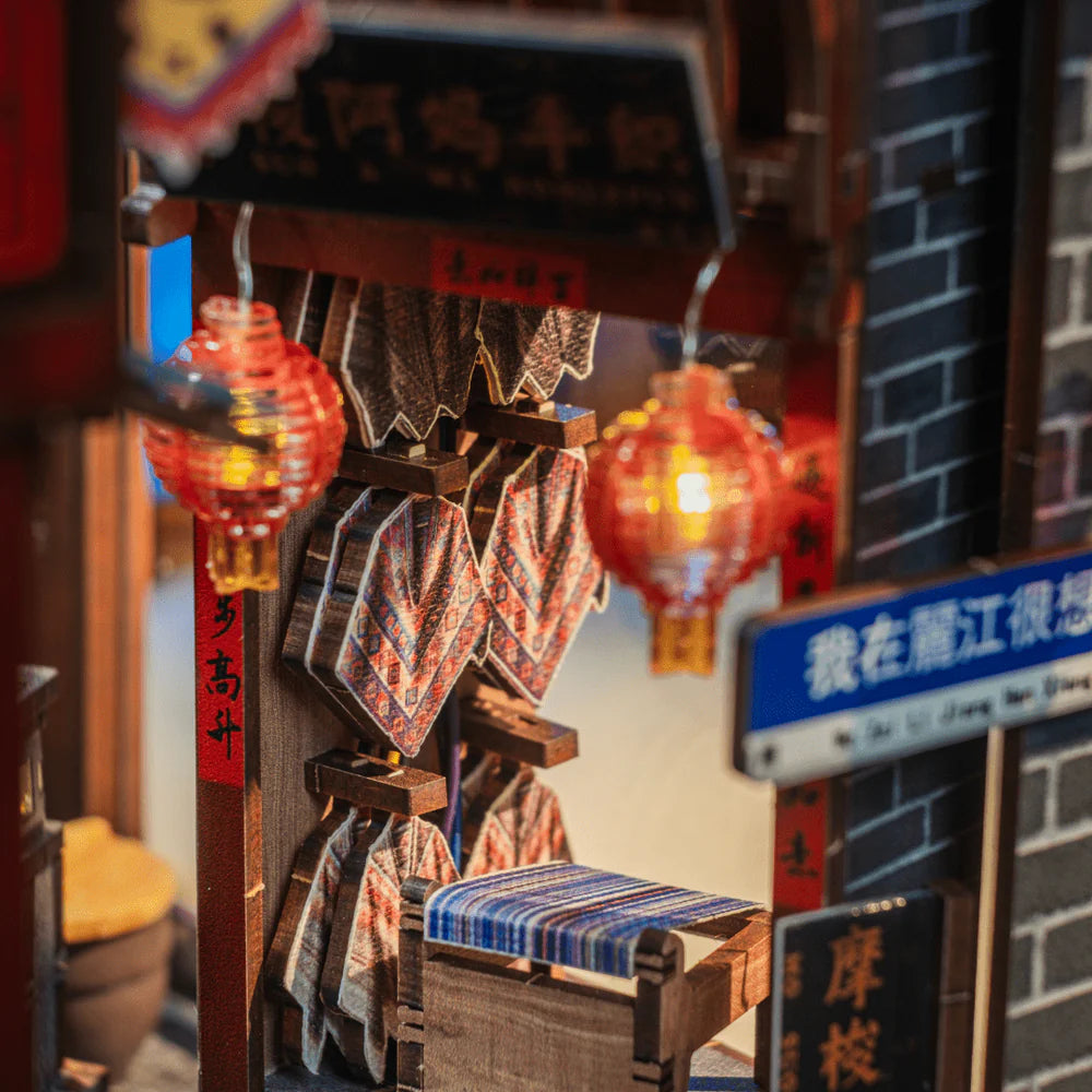 Nahaufnahme eines Miniatur-Dioramas einer chinesischen Straße mit roten Laternen und einem blauen Schild