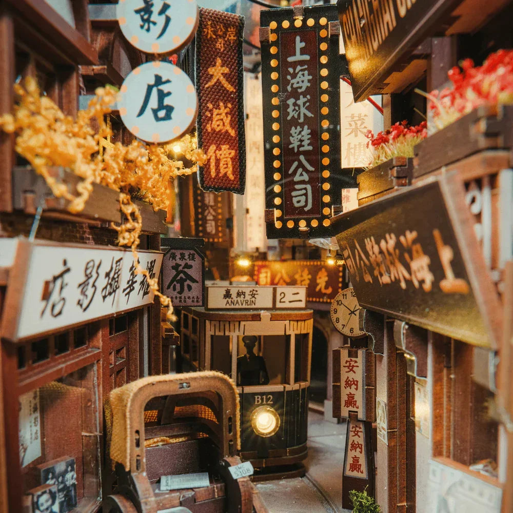 Miniatur-Straßenszene mit Straßenbahn, Rikschas und beleuchteten Schildern in asiatischer Schrift