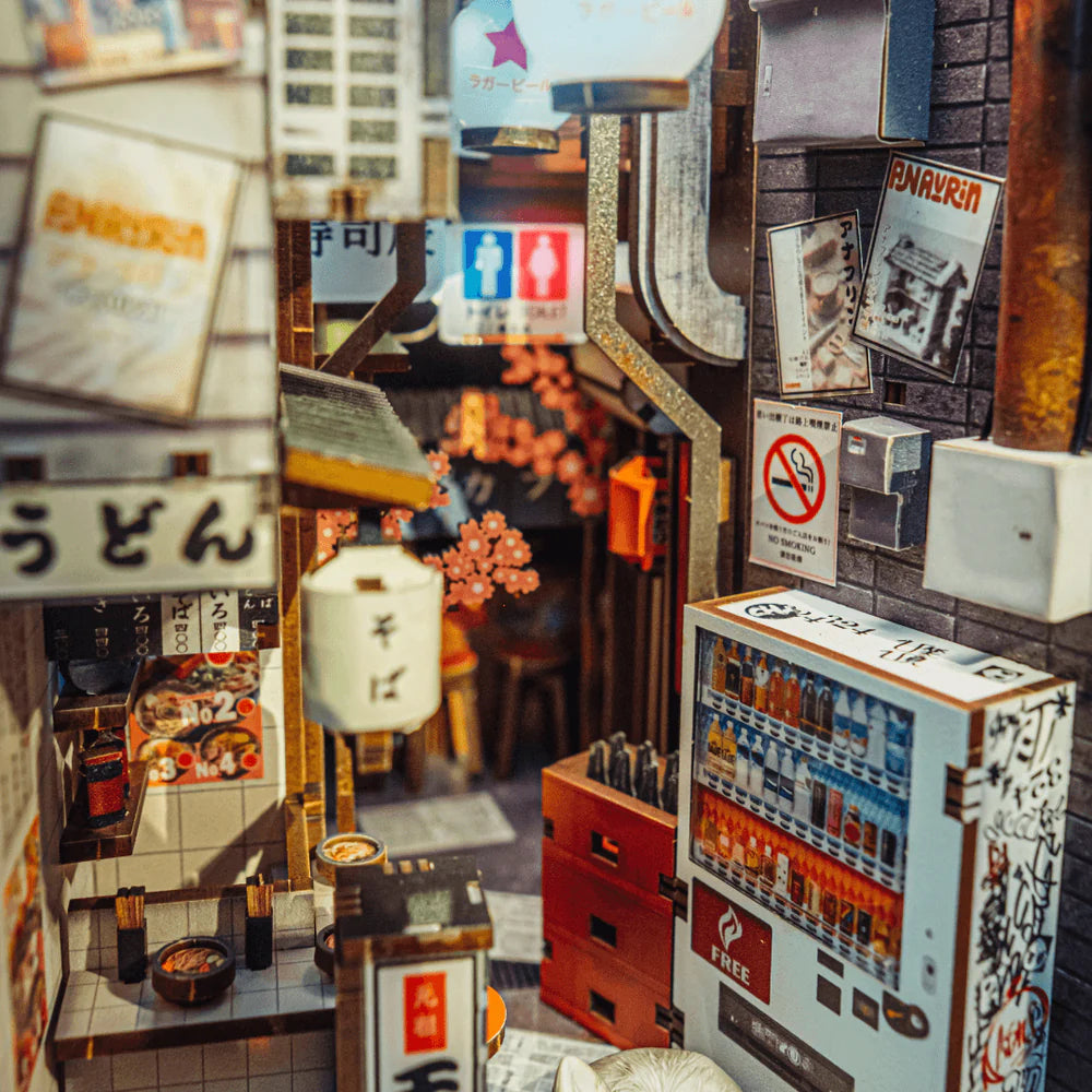 Miniatur-Straßenszene in Japan mit Automaten, Schildern und Kirschblüten
