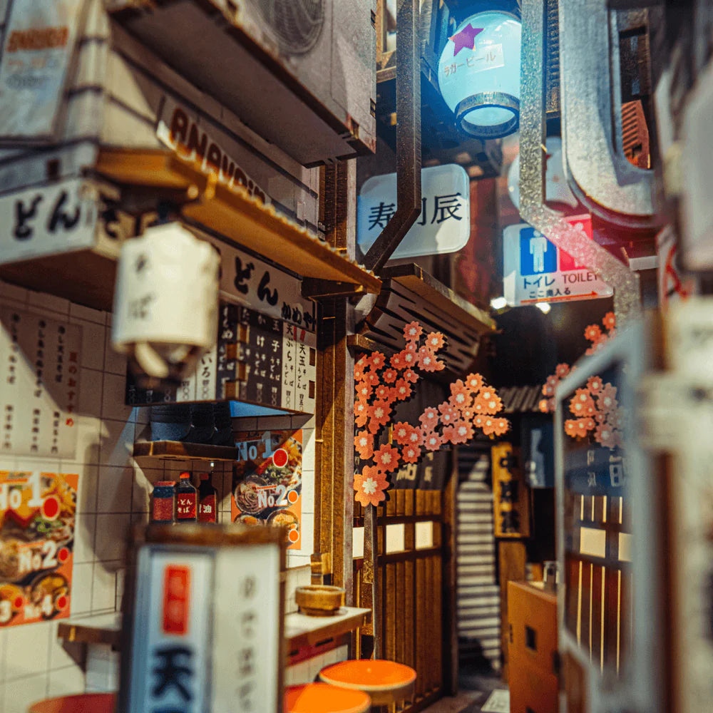 Miniatur-Gasse in Japan mit Geschäften, Laternen und Kirschblüten