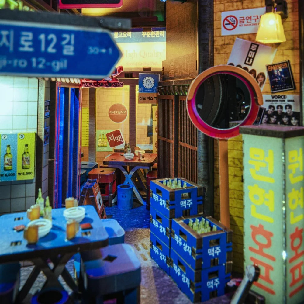 Miniatur-Straßenszene in Korea mit Tischen, Stühlen, Bierkästen und Schildern