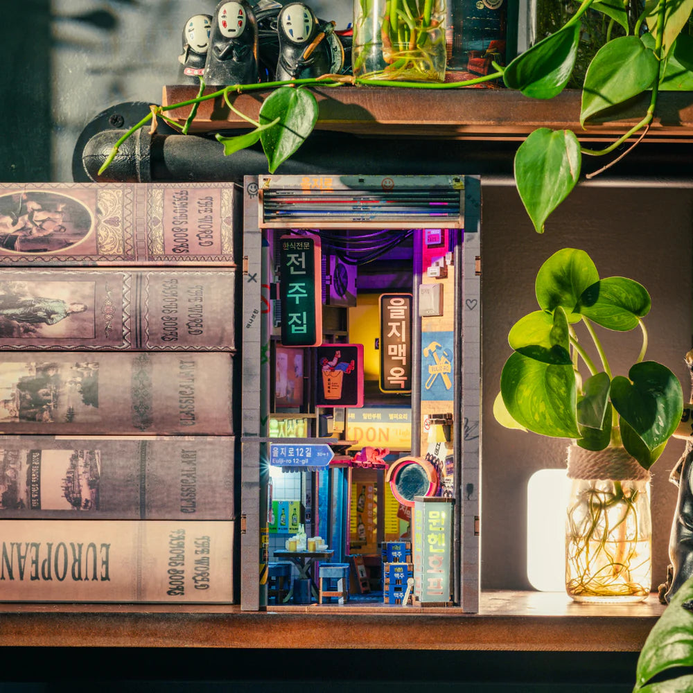 Miniatur-Diorama eines beleuchteten koreanischen Straßenzugs mit Büchern und Pflanzen