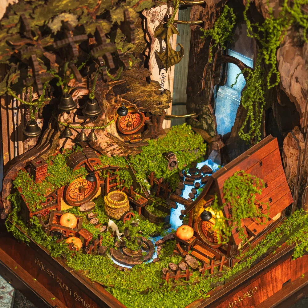 Miniatur-Diorama eines Hobbit-Dorfes mit Häusern, Bäumen, Wasserfall und Moos