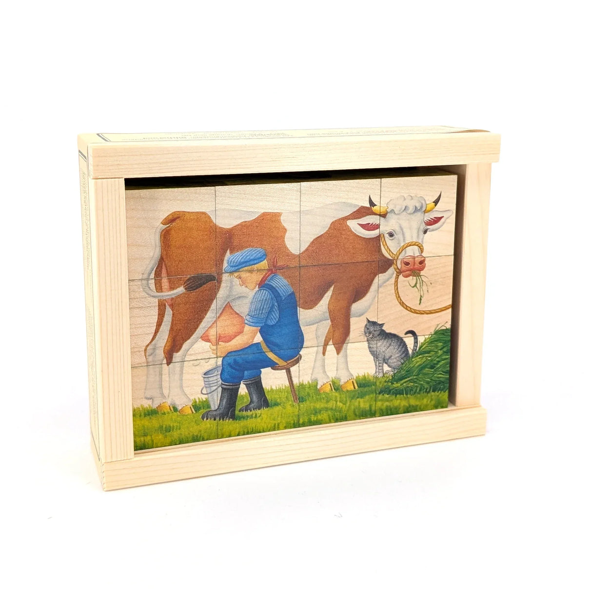 Holzpuzzle mit einem Bauern, der eine Kuh melkt, während eine Katze daneben sitzt