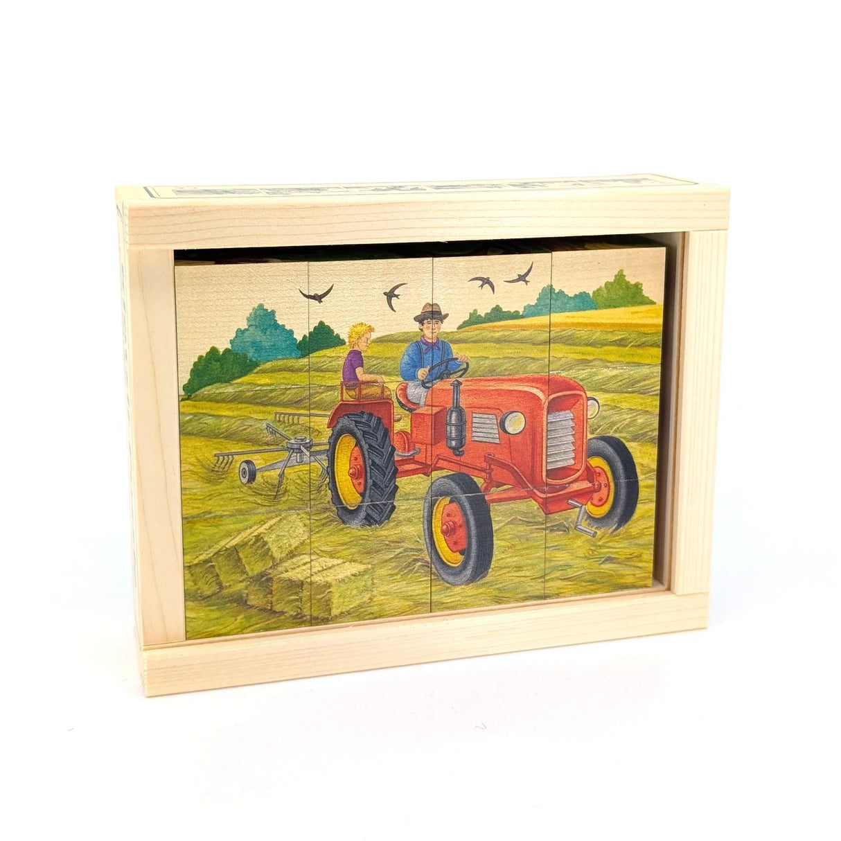 Holzpuzzle mit einem roten Traktor, der Heu auf einem Feld sammelt, mit zwei Personen und Vögeln am Himmel