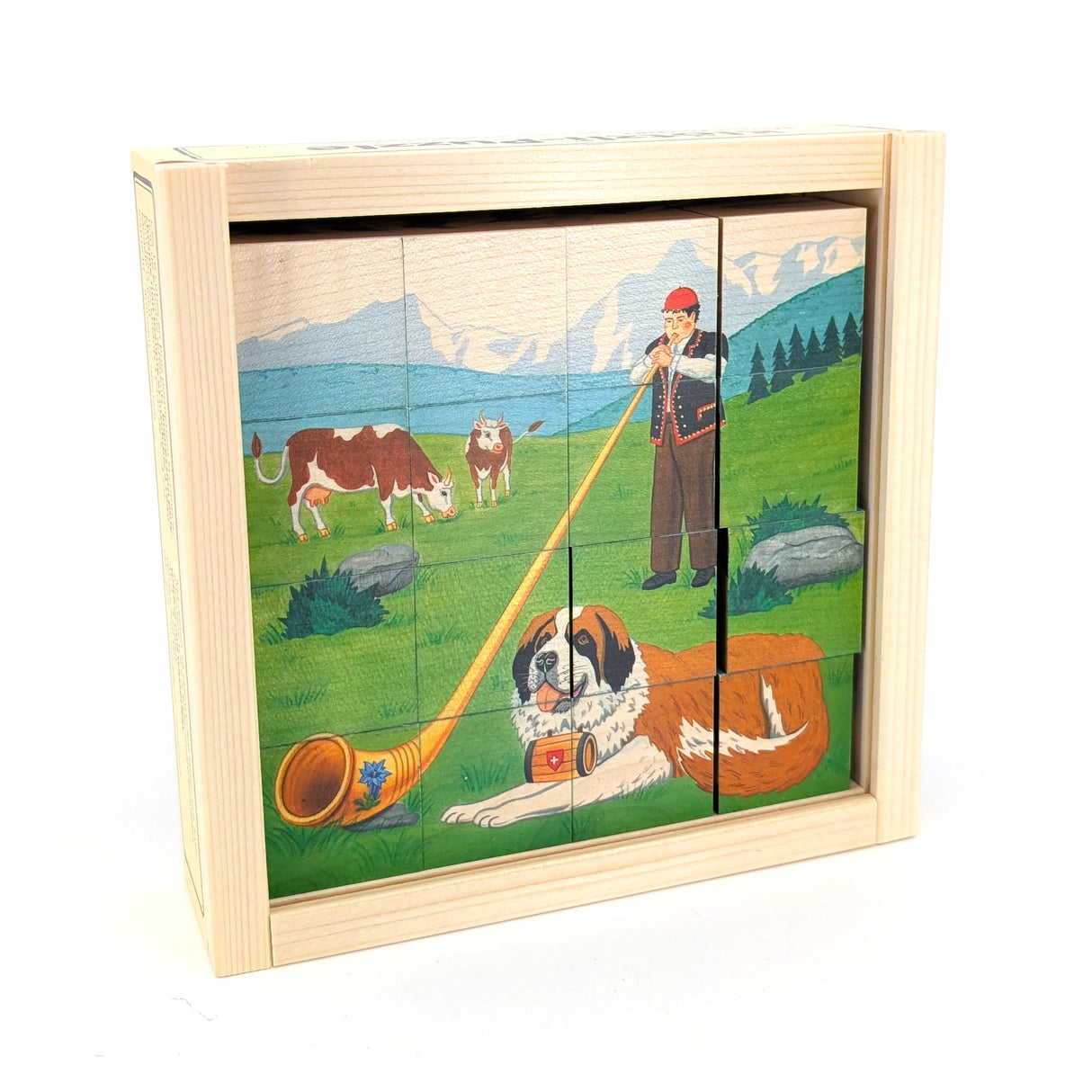 Holzwürfelpuzzle mit Schweizer Alpenszene, Alphornbläser, Kühen und Bernhardinerhund