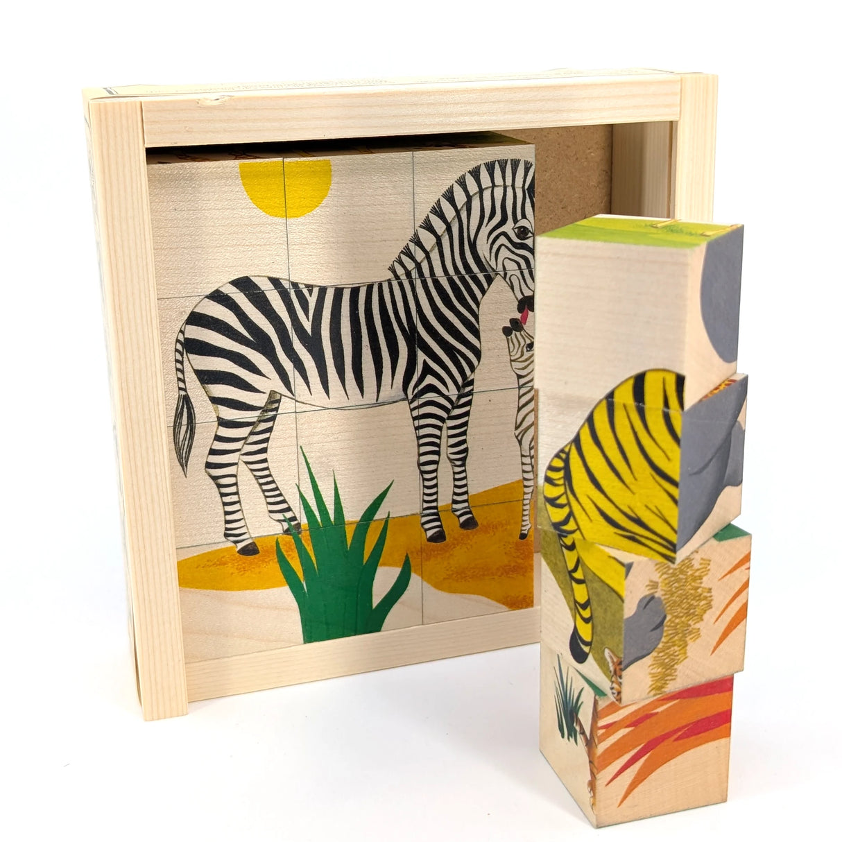 Holzpuzzle mit Zebra und Babyzebra in der Savanne, daneben gestapelte Würfel mit Tiermotiven