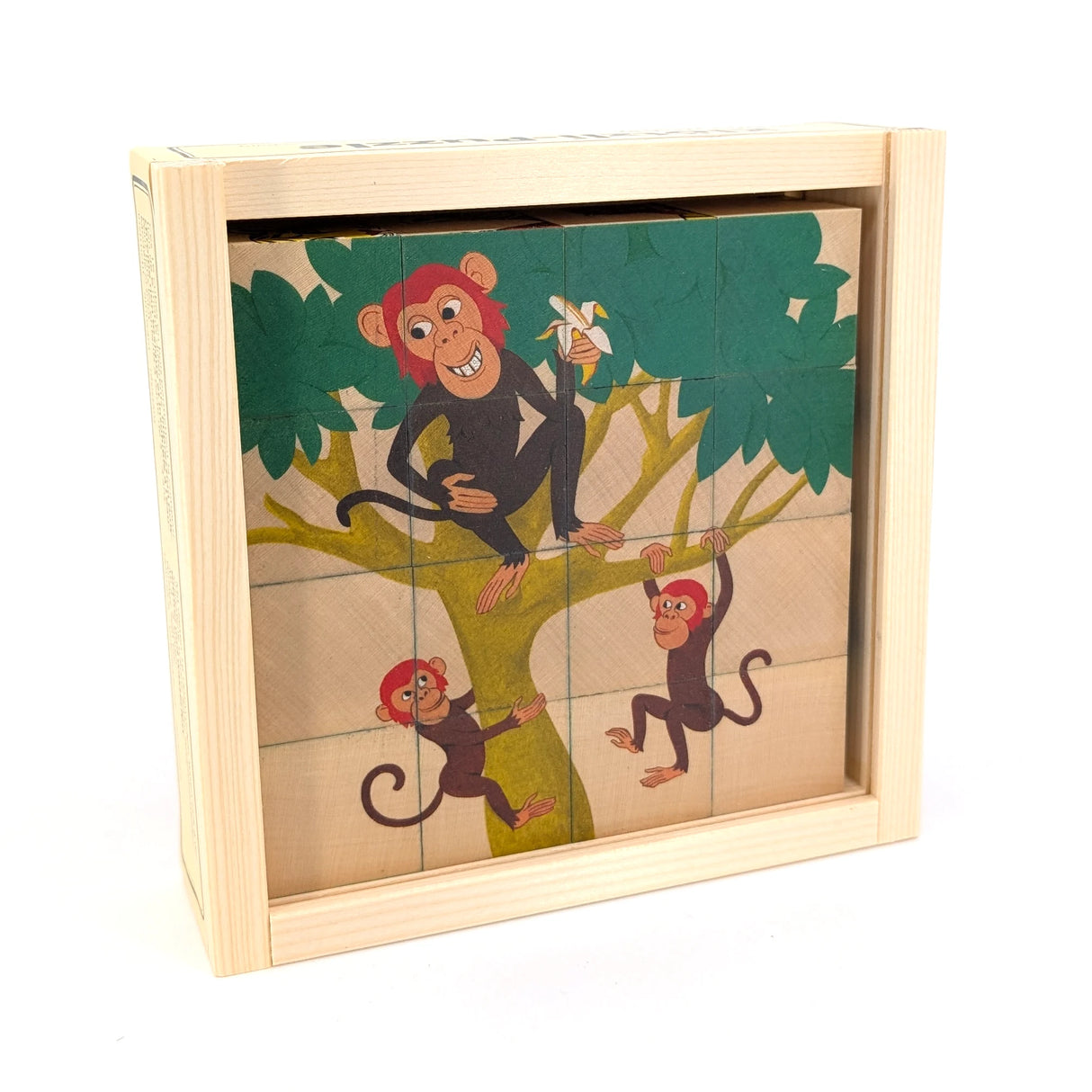 Holzpuzzle mit drei Affen in einem Baum, einer isst eine Banane