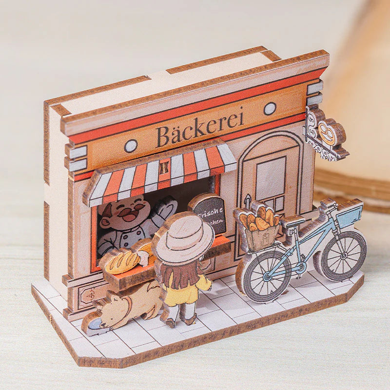Holzmodell einer Bäckerei mit Bäcker, Kundin, Hund und Fahrrad
