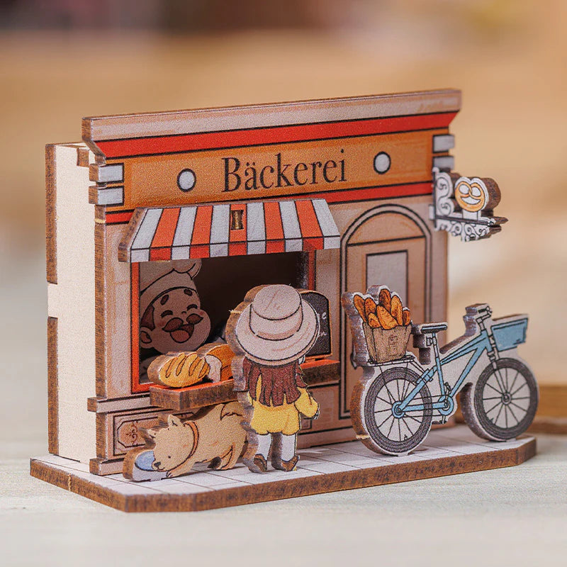 Holzmodell einer Bäckerei mit Bäcker, Kunde, Hund und Fahrrad