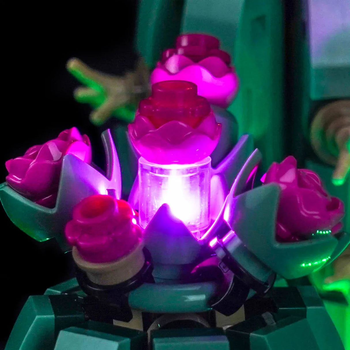 Detailansicht der kleineren, lila-pink leuchtenden LEGO Kaktusknospen mit integrierten Mini-LEDs vor dunklem Hintergrund.
