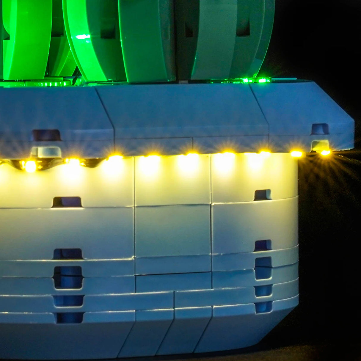 Nahaufnahme der warmweißen LED-Lichterkette, die unter dem Rand des blauen LEGO-Kaktustopfs verläuft.