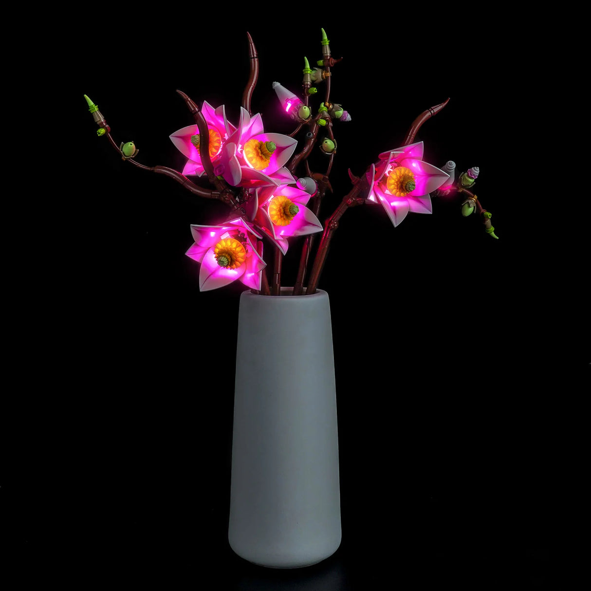 Das LEGO Botanicals Magnolien-Set dekorativ beleuchtet mit einem farbintensiven LED-Lichtkit bei Nacht.