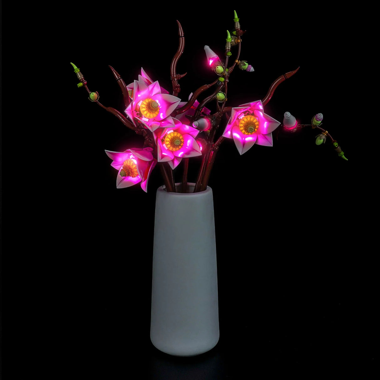 BrickBling LED-Beleuchtungsset für LEGO Magnolienzweige (Set 11510) in einer hohen grauen Vase, Ansicht von vorne links.