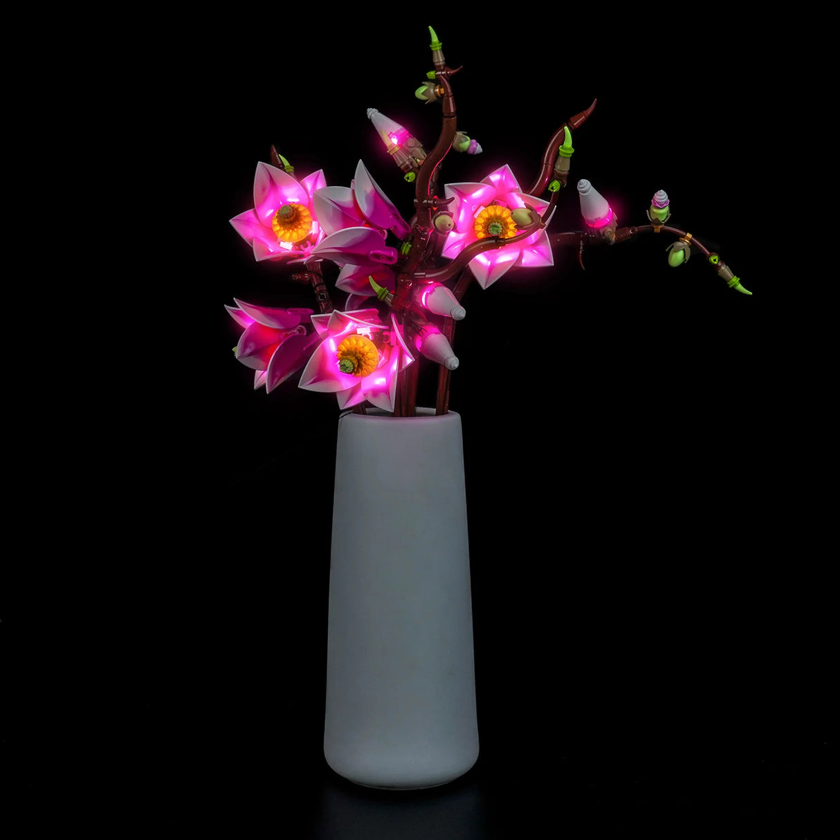 Rechte Seitenansicht der beleuchteten LEGO Magnolienblüten in einer Vase mit Fokus auf die strahlenden, pinken LED-Effekte.