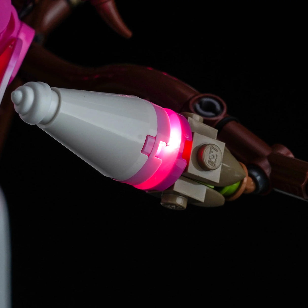 Detailaufnahme einer geschlossenen LEGO Magnolienknospe mit integriertem, pink leuchtendem BrickBling LED-Licht.