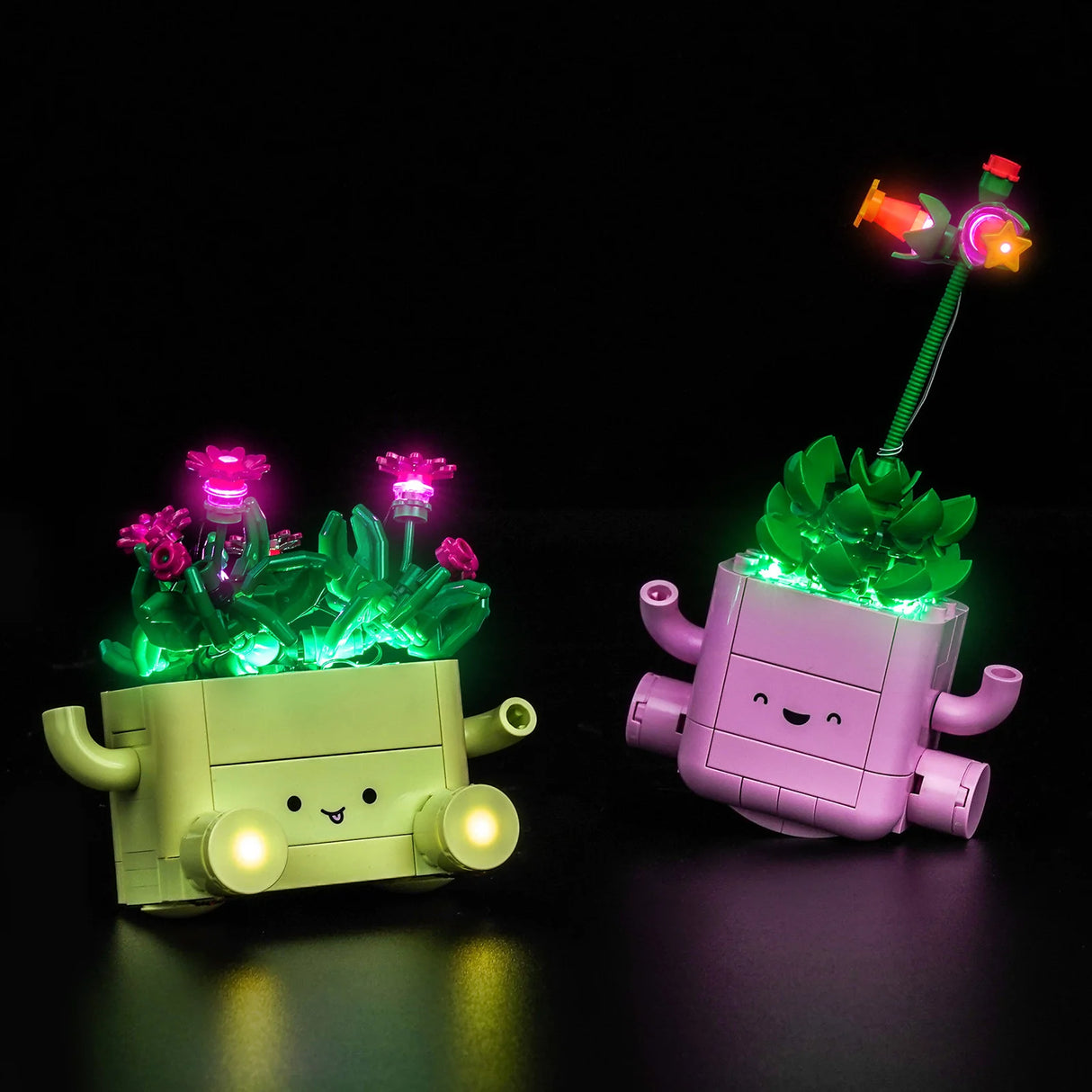 Das LEGO-Set Schaukelnde Pflanzen in Grün und Rosa, effektvoll inszeniert mit bunten BrickBling LED-Lichtern vor schwarzem Hintergrund.