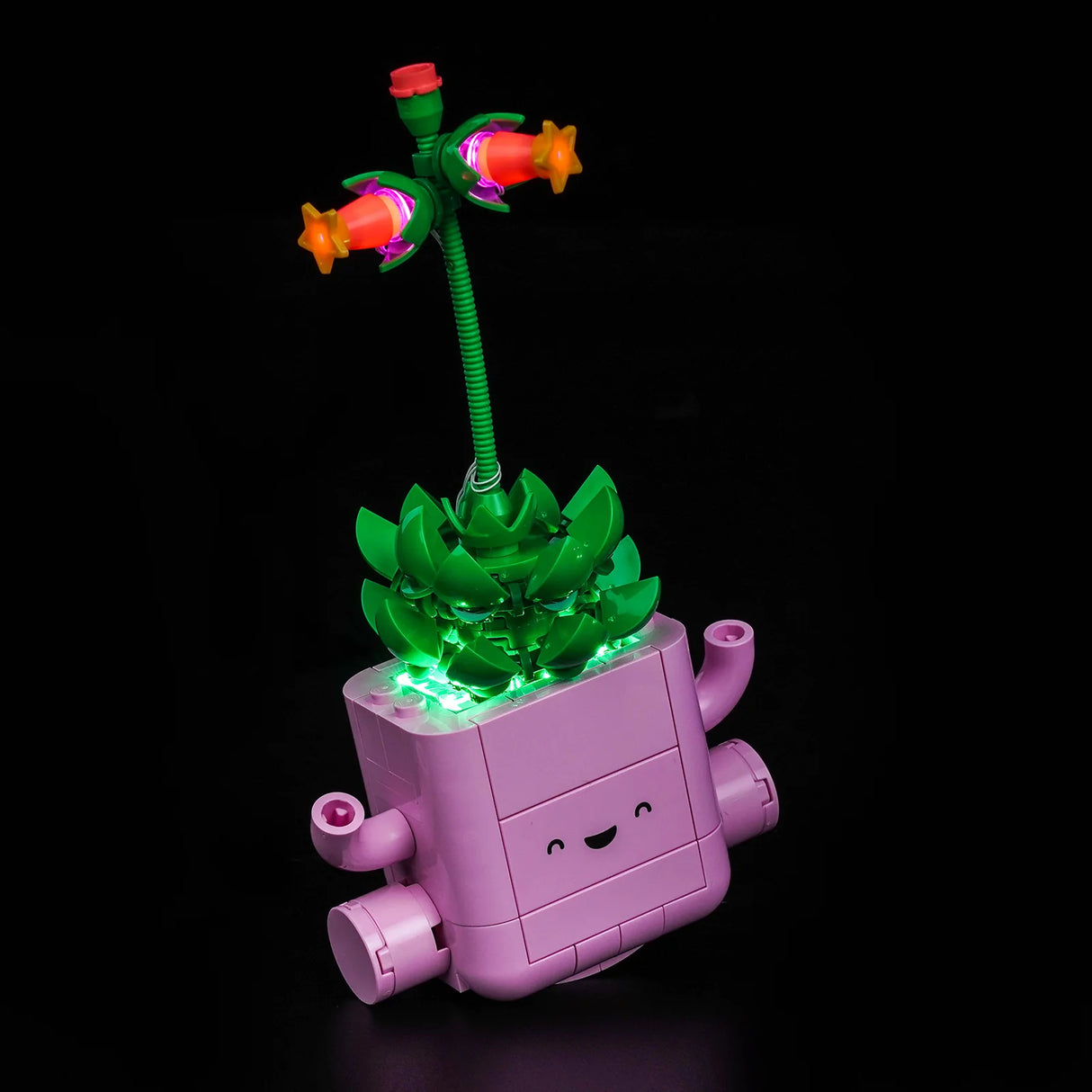 Ein schaukelnder rosa LEGO-Blumentopf mit Sukkulente und einer hohen Blume, beleuchtet mit dem BrickBling LED-Kit.