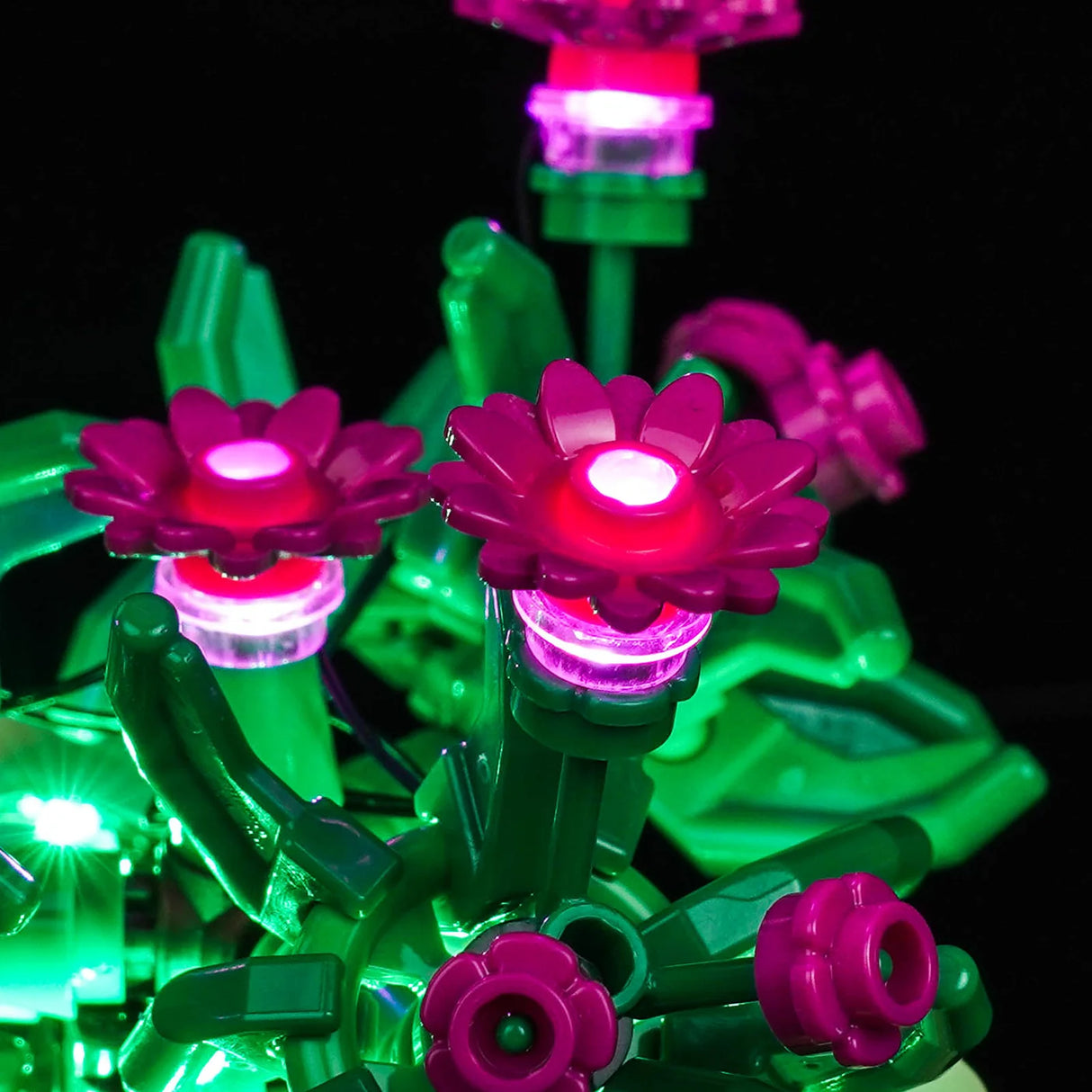 Nahaufnahme von pinken LEGO-Blumen, die durch ein integriertes LED-Lichtset von BrickBling hell leuchten.