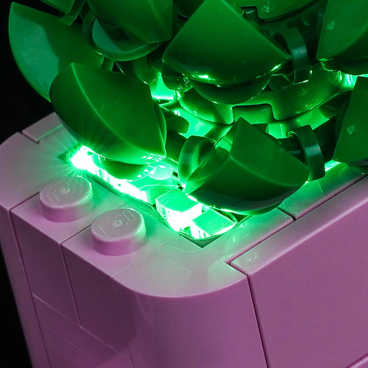 Detailansicht der grünen LED-Beleuchtung im Inneren eines rosa LEGO-Blumentopfs von BrickBling.