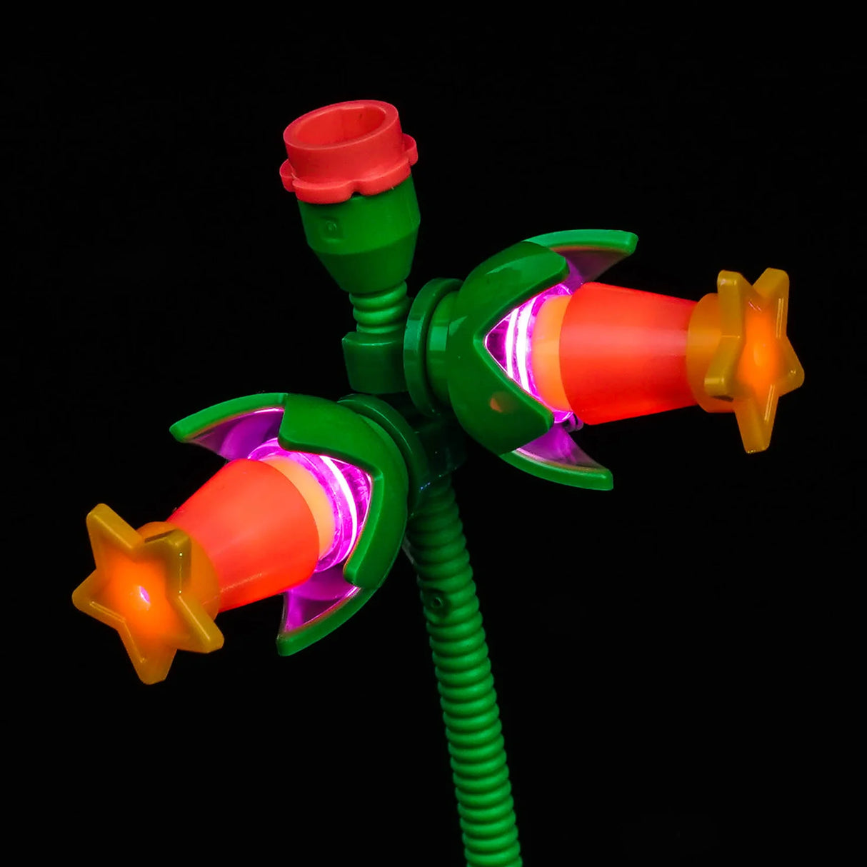 Nahaufnahme einer LEGO-Blume mit orangefarbenen Blütenblättern und leuchtend pinker LED-Beleuchtung von BrickBling auf grünem Stiel.