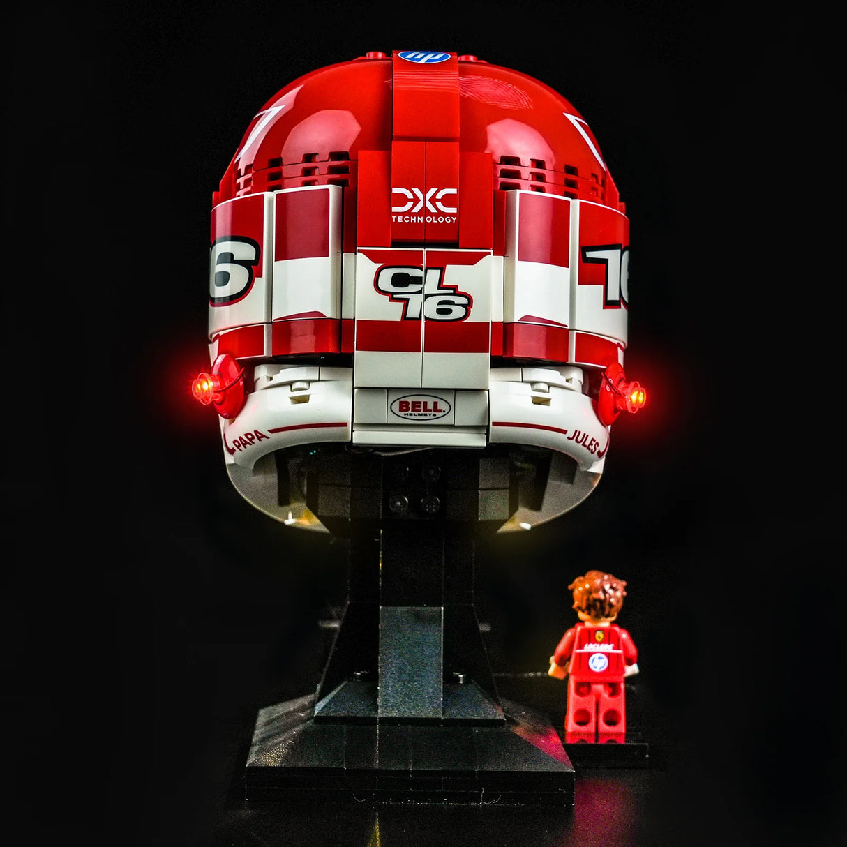 Rückansicht des LEGO Scuderia Ferrari Charles Leclerc Helms mit leuchtenden roten BrickBling LED-Rücklichtern und einer kleinen Leclerc Minifigur daneben.