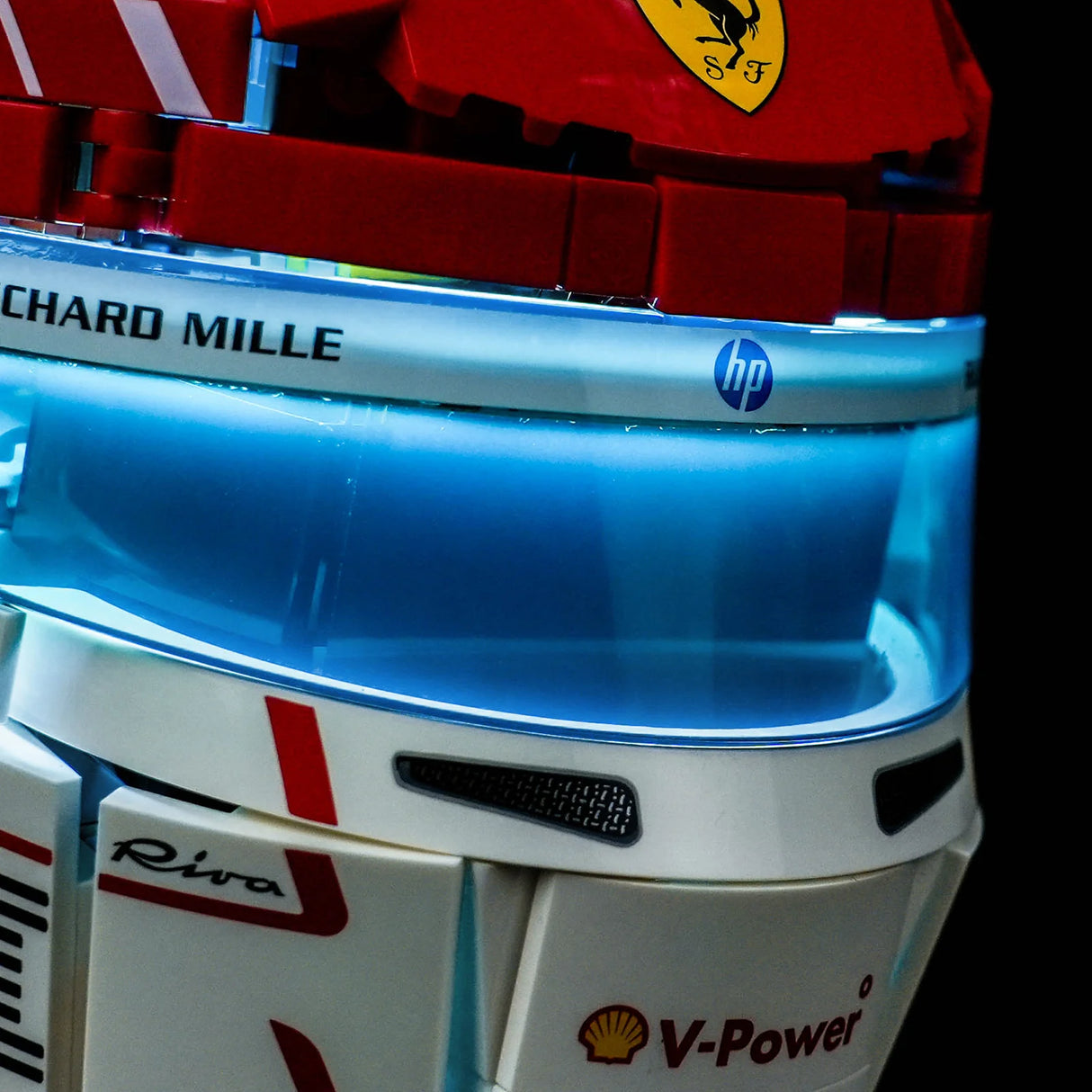 Detailansicht des blau beleuchteten Visiers des LEGO Charles Leclerc Ferrari Helms mit HP- und Richard Mille-Sponsorenlogos.