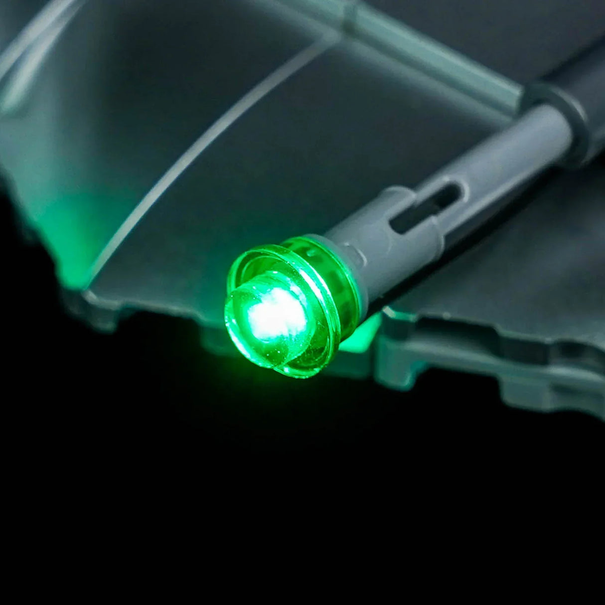 Nahaufnahme eines grünen BrickBling LED-Lichts an der Spitze des LEGO Star Wars Mandalorianer N-1 Starfighter (75442) in einer dunklen Umgebung.